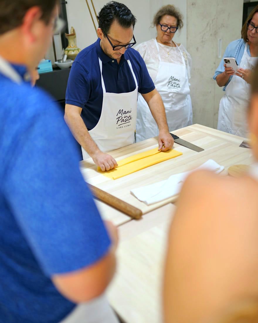 The chef folds the sfoglia while guests watch closely