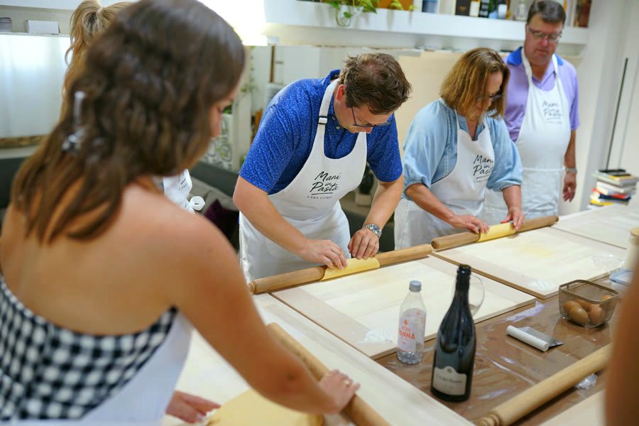 Guests rolling the sfoglia with the rolling pin during the tagliatelle class in Como